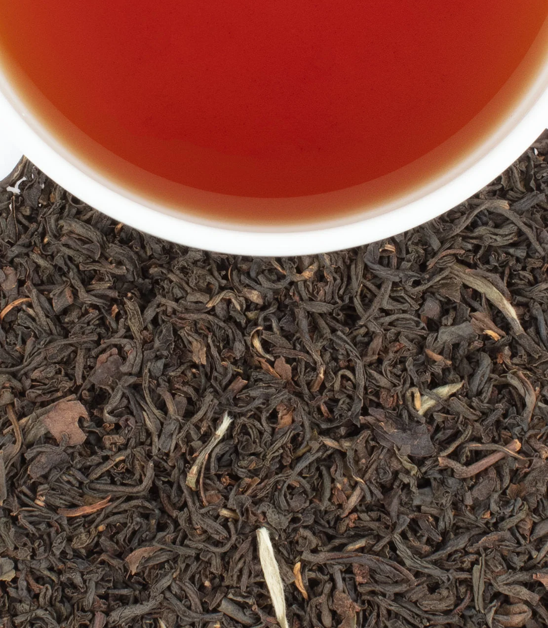A cup of Harney & Sons Earl Grey Supreme above loose tea leaves