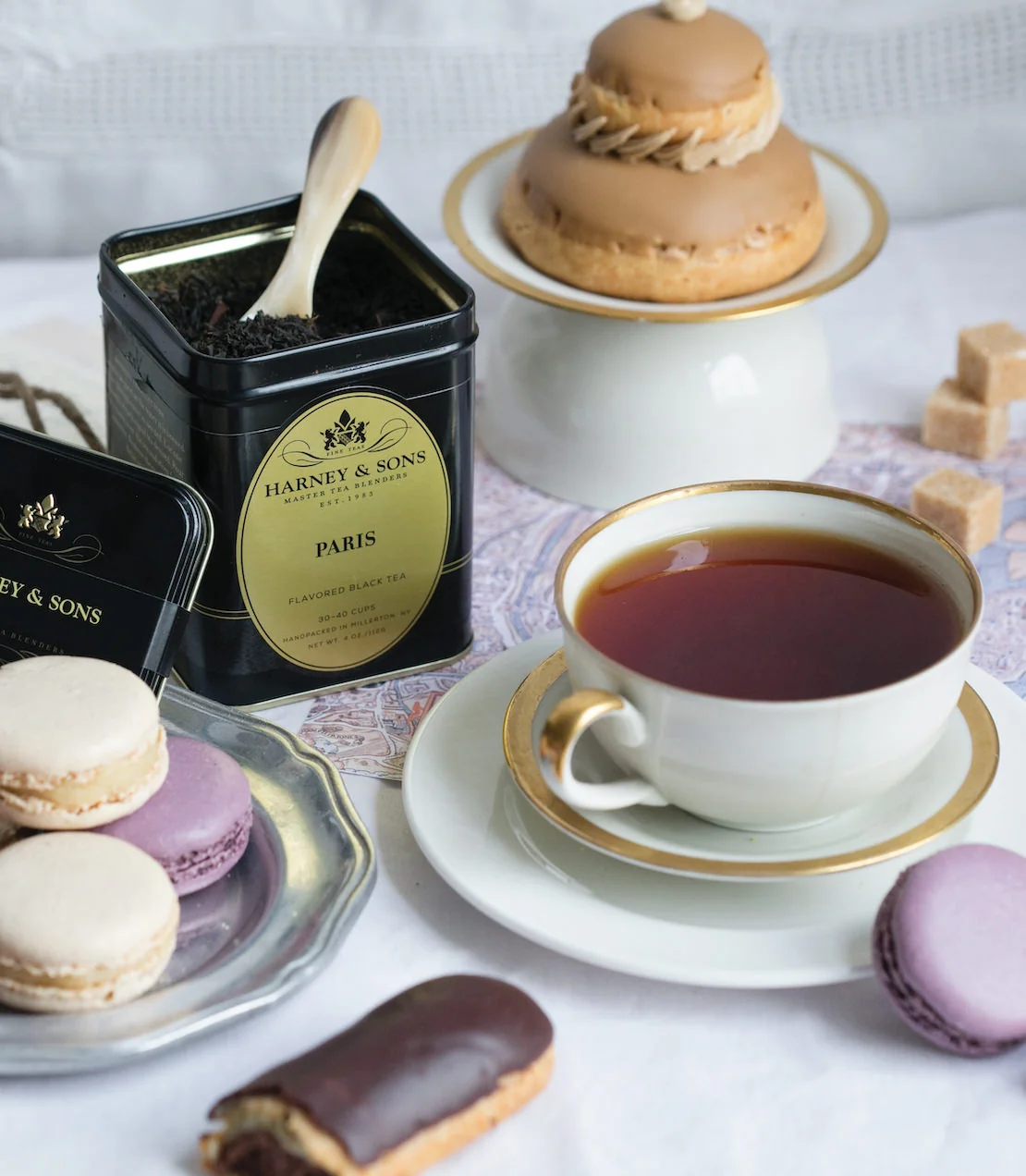 Harney & Sons Paris tea, macarons and pastries arranged on a white table