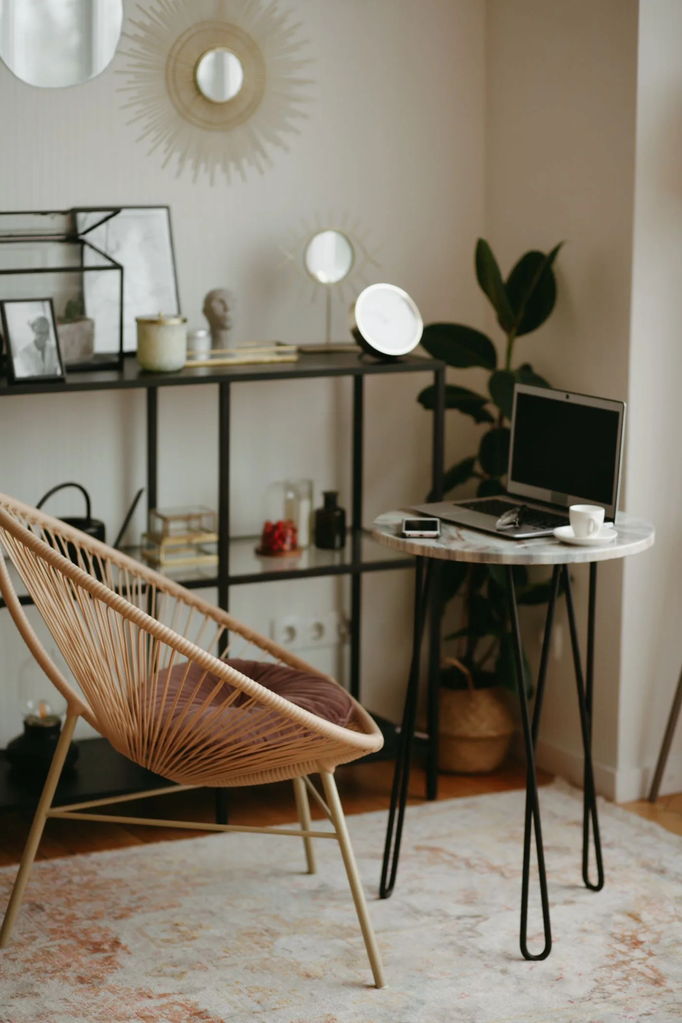 A home workspace with a laptop, chair, shelves and decor.