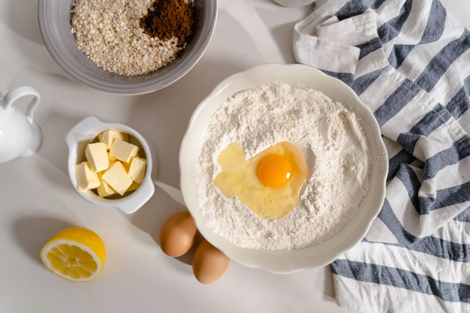 Bowls of baking ingredients on a white surface