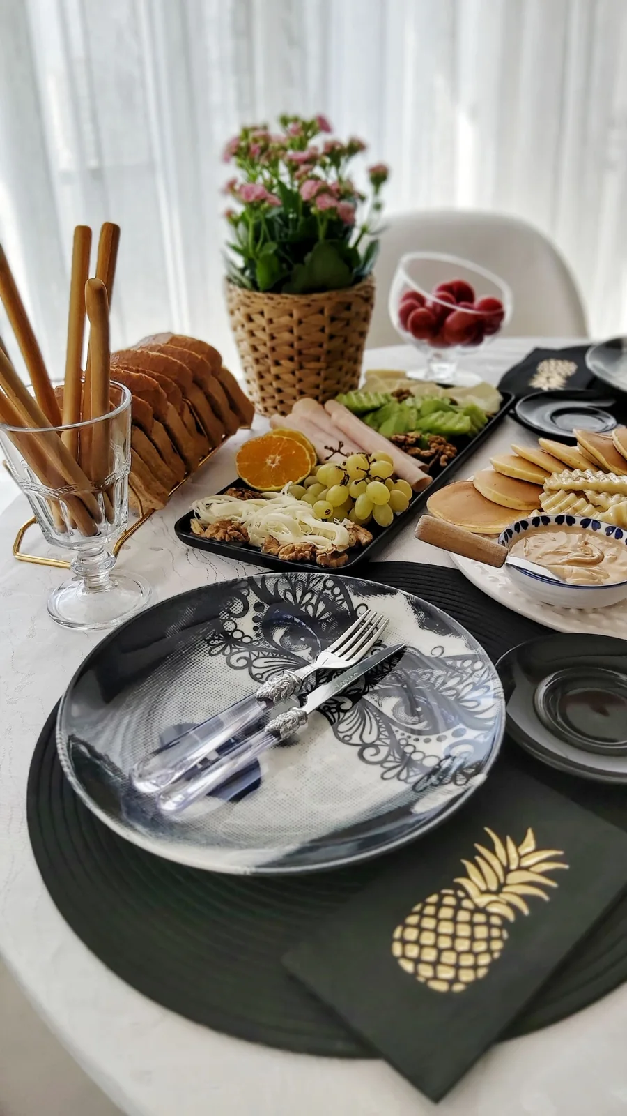 Cheese, grapes, citrus and crackers arranged beside a place setting