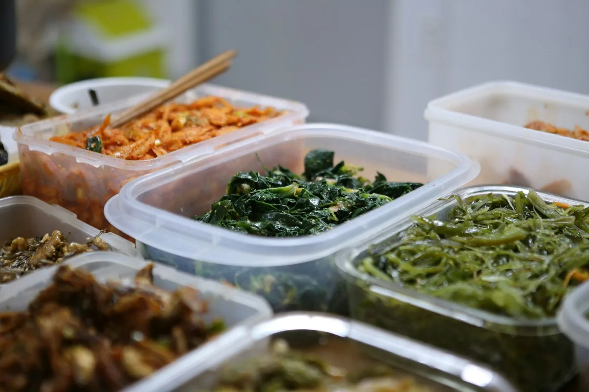 Several open food containers holding prepared dishes