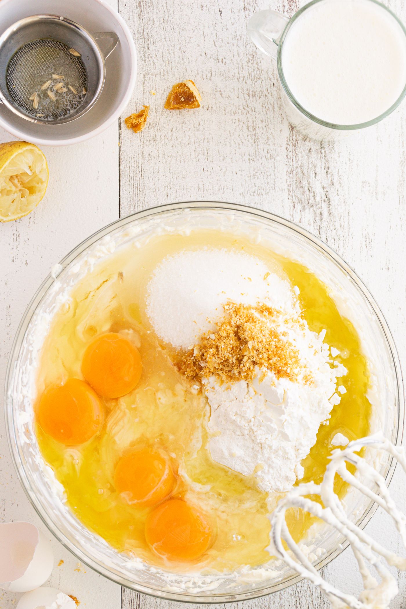 Eggs and other baking ingredients in a clear mixing bowl.