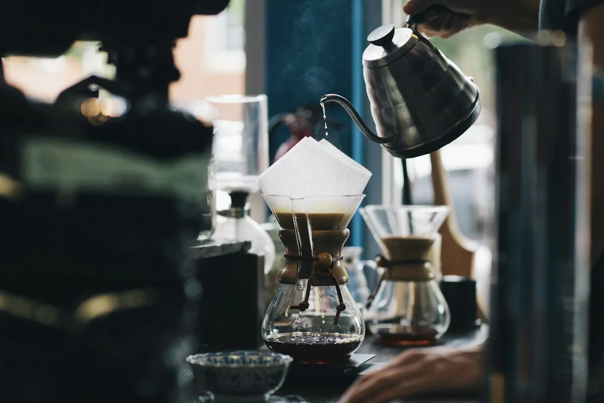 Pour-over coffee equipment with a dark kettle and glass brewer.