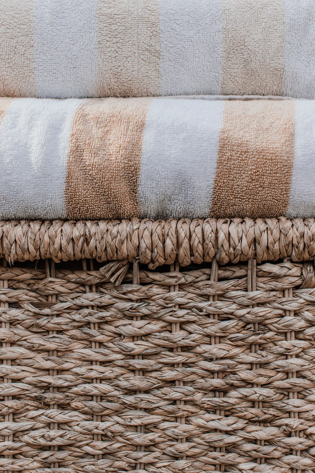 Folded fringed throws in neutral tones.