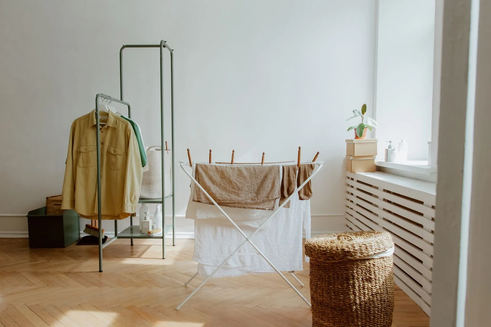 Clothes on a drying rack beside a window.