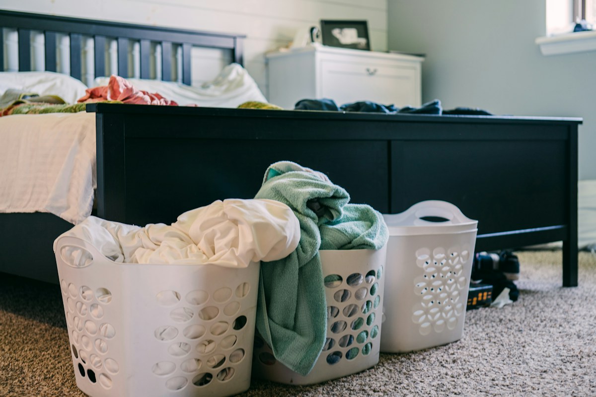 Laundry baskets holding clothing in a bedroom.