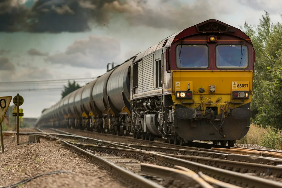 A passenger train on railway tracks in open countryside.
