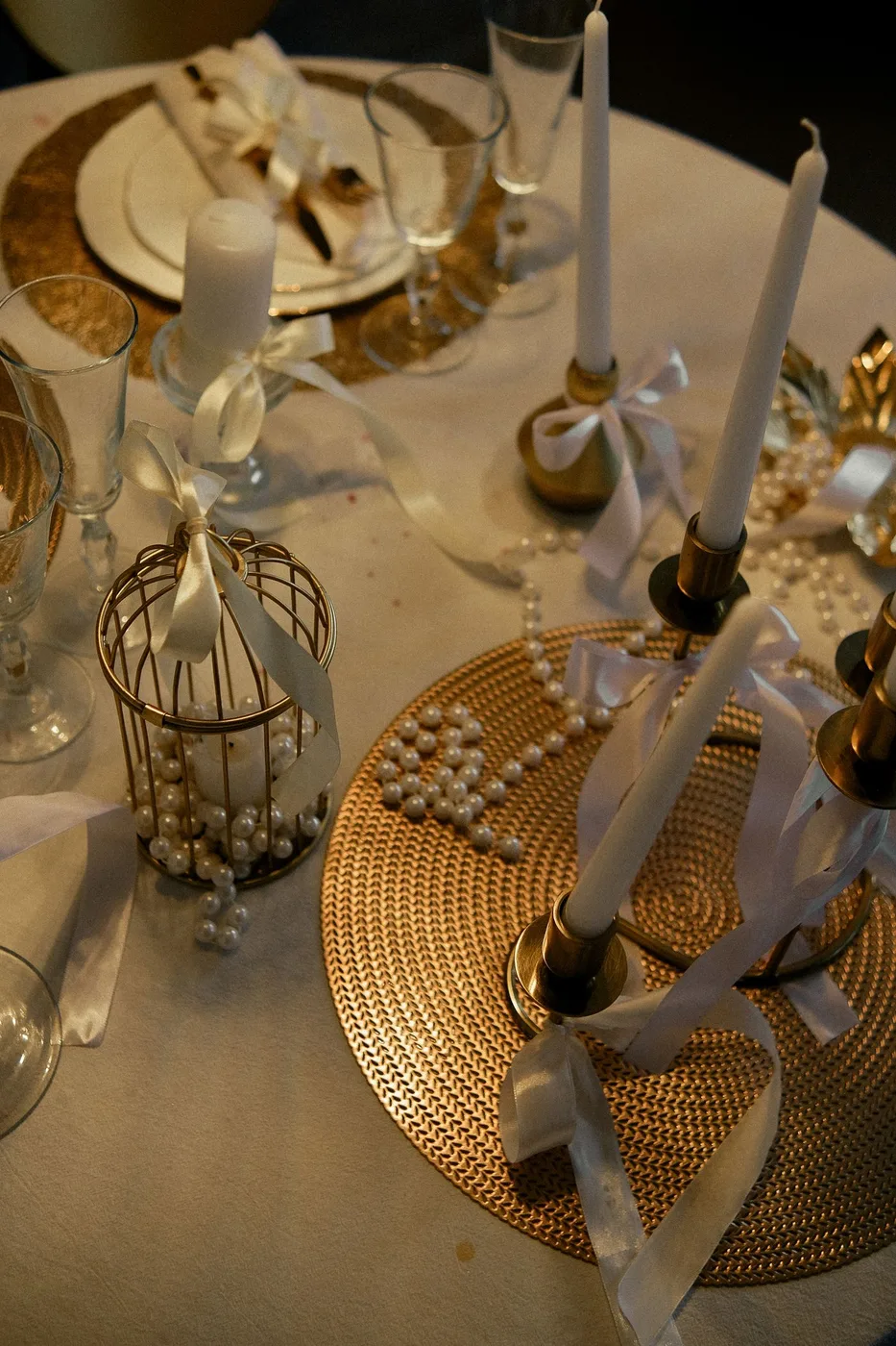 Candles and glassware arranged on a decorated dining table.