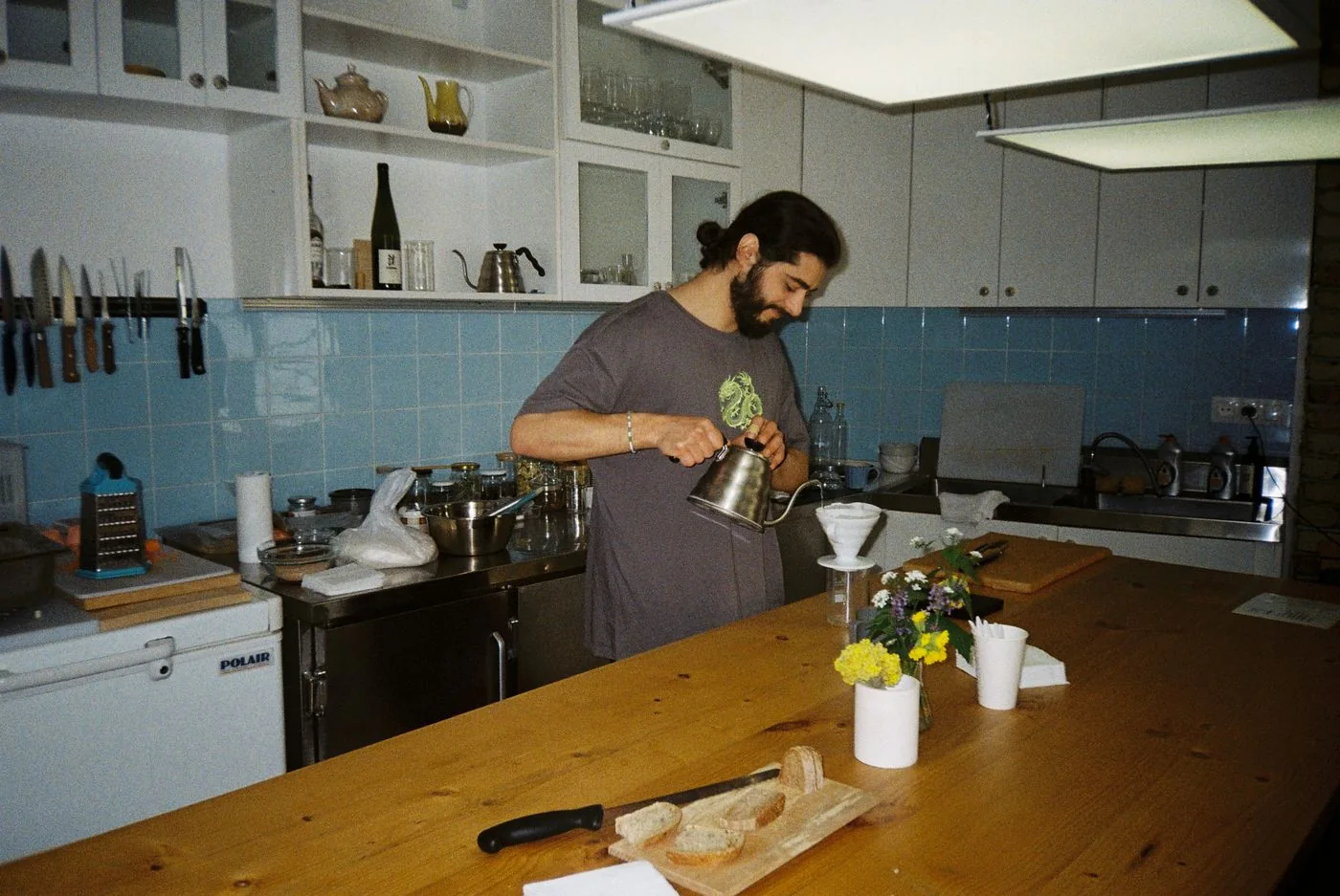 Man preparing pour-over coffee in a home kitchen